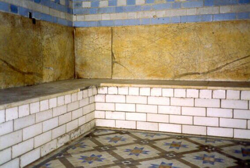 A corner of the hot room with marble seats and tiled floor